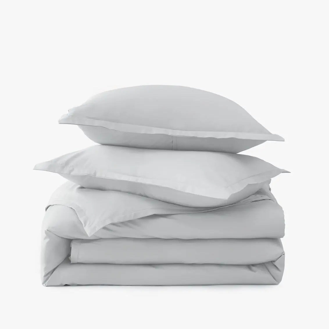 Stack of light gray bedding with two pillows on a white background