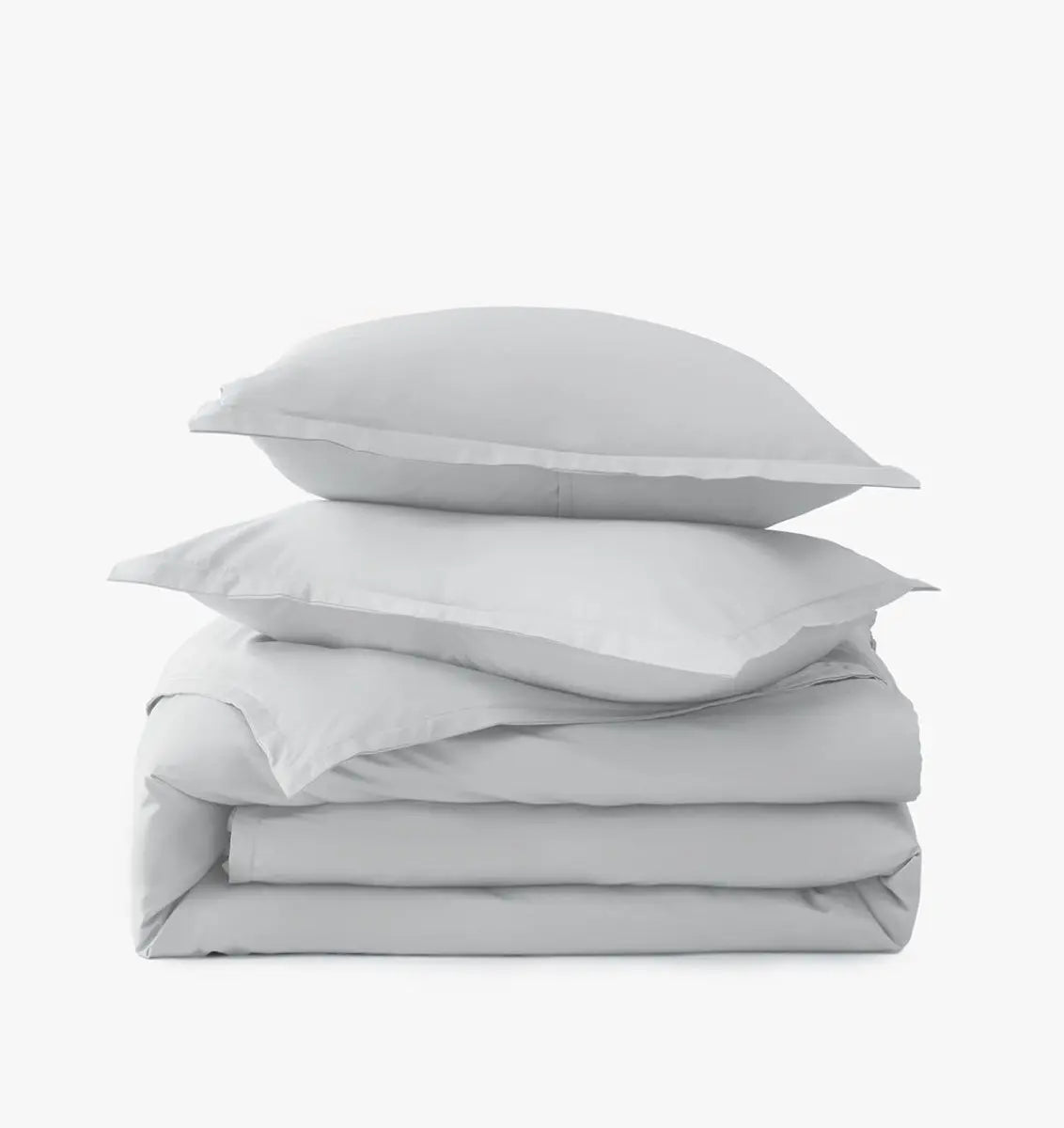 Stack of light gray bedding with two pillows on a white background