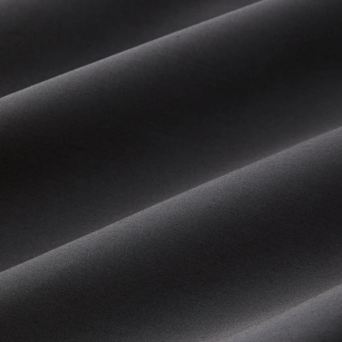 Close-up of slate gray bed sheet fabric with folds