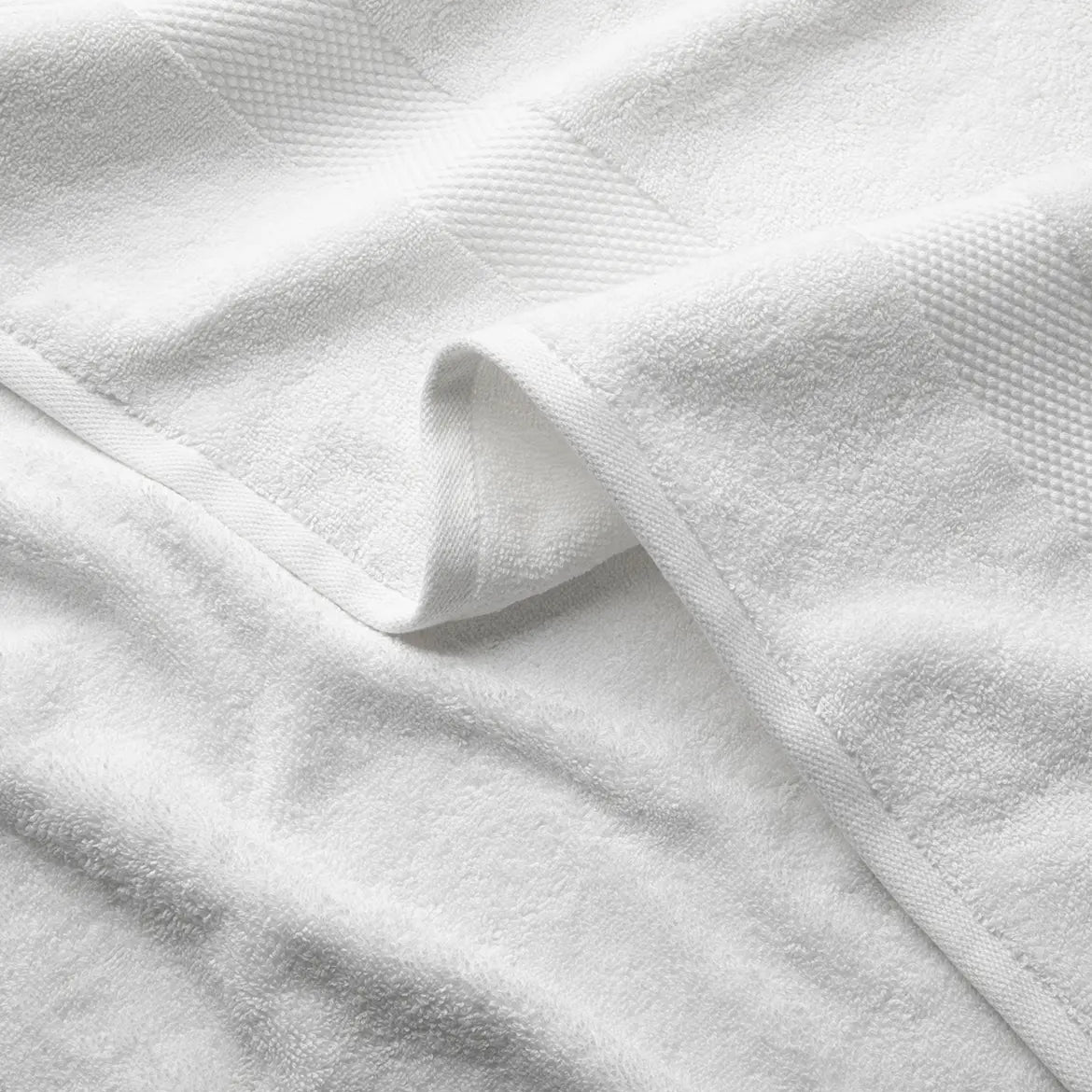 Close-up of white textured premium Turkish cotton towels with a folded corner.