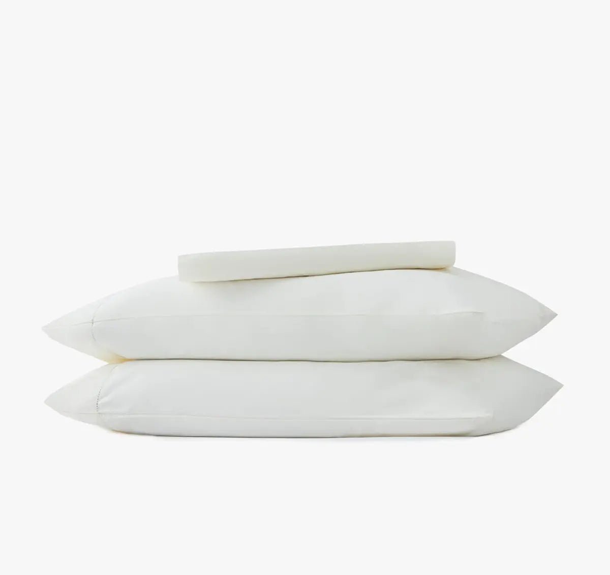 Stack of ivory white pillowcases and sheet set on a white background