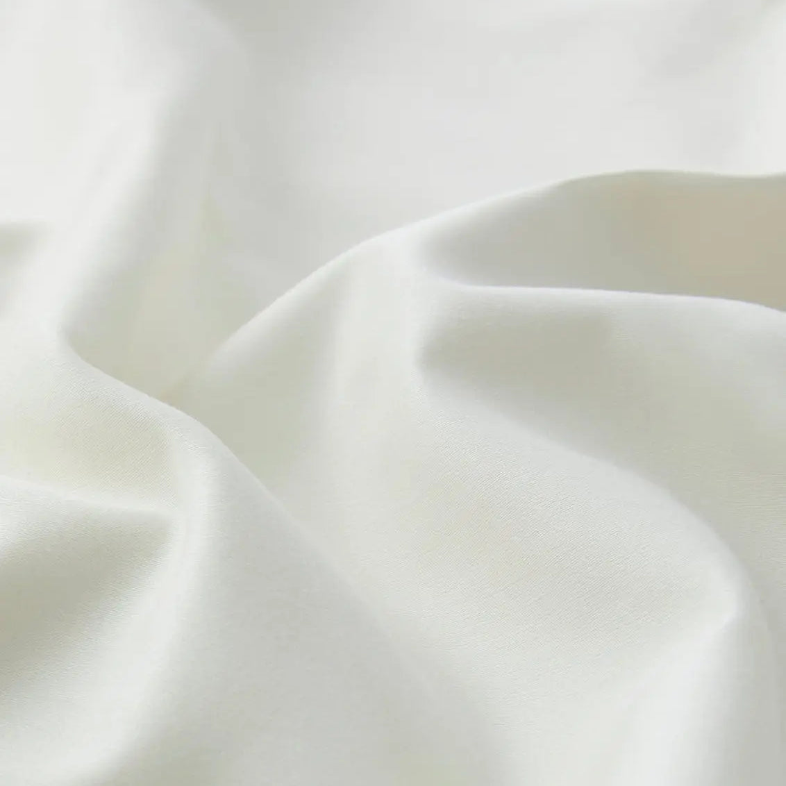 Close-up of an ivory white sheet set fabric with folds