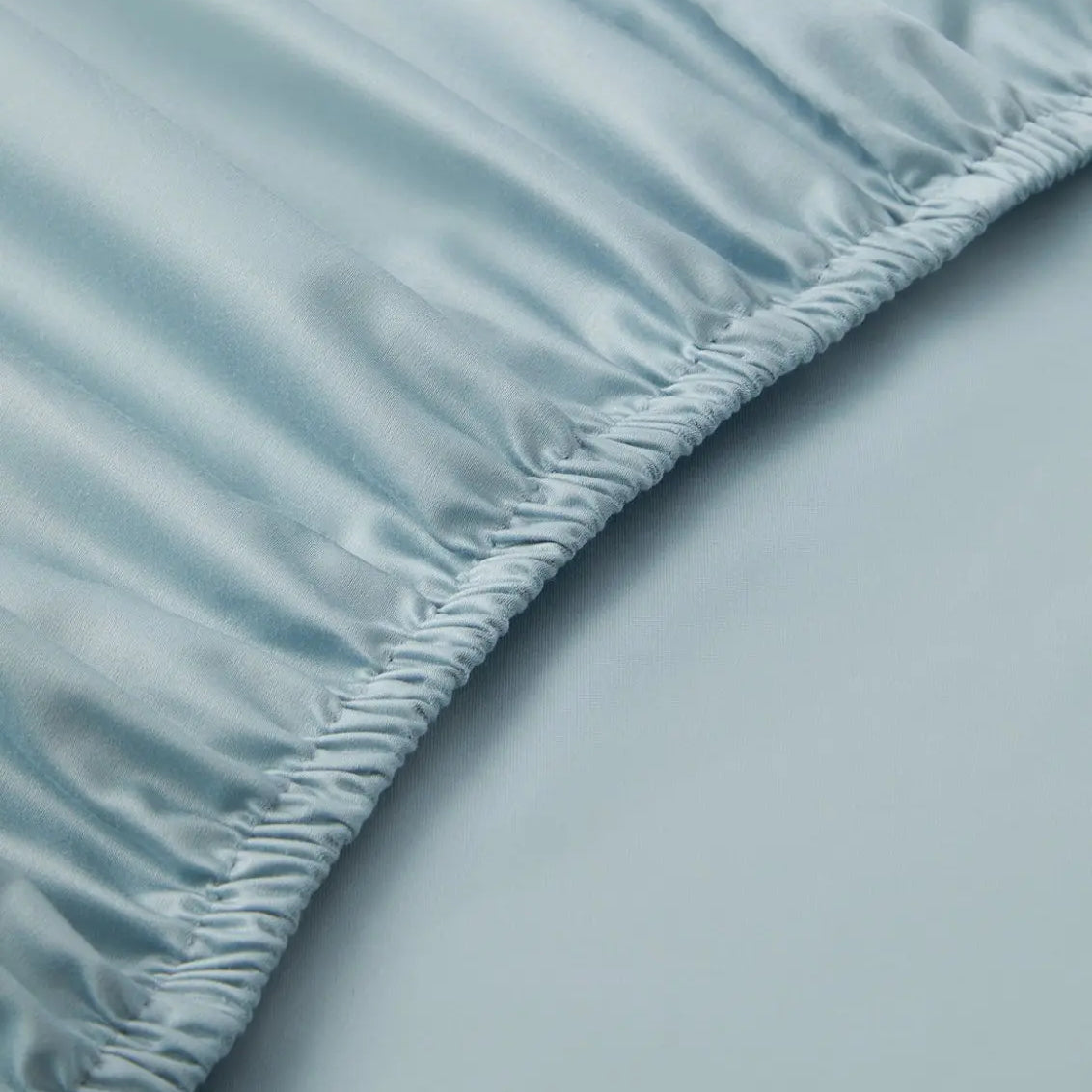 Close-up of a light blue fitted sheet on a bed
