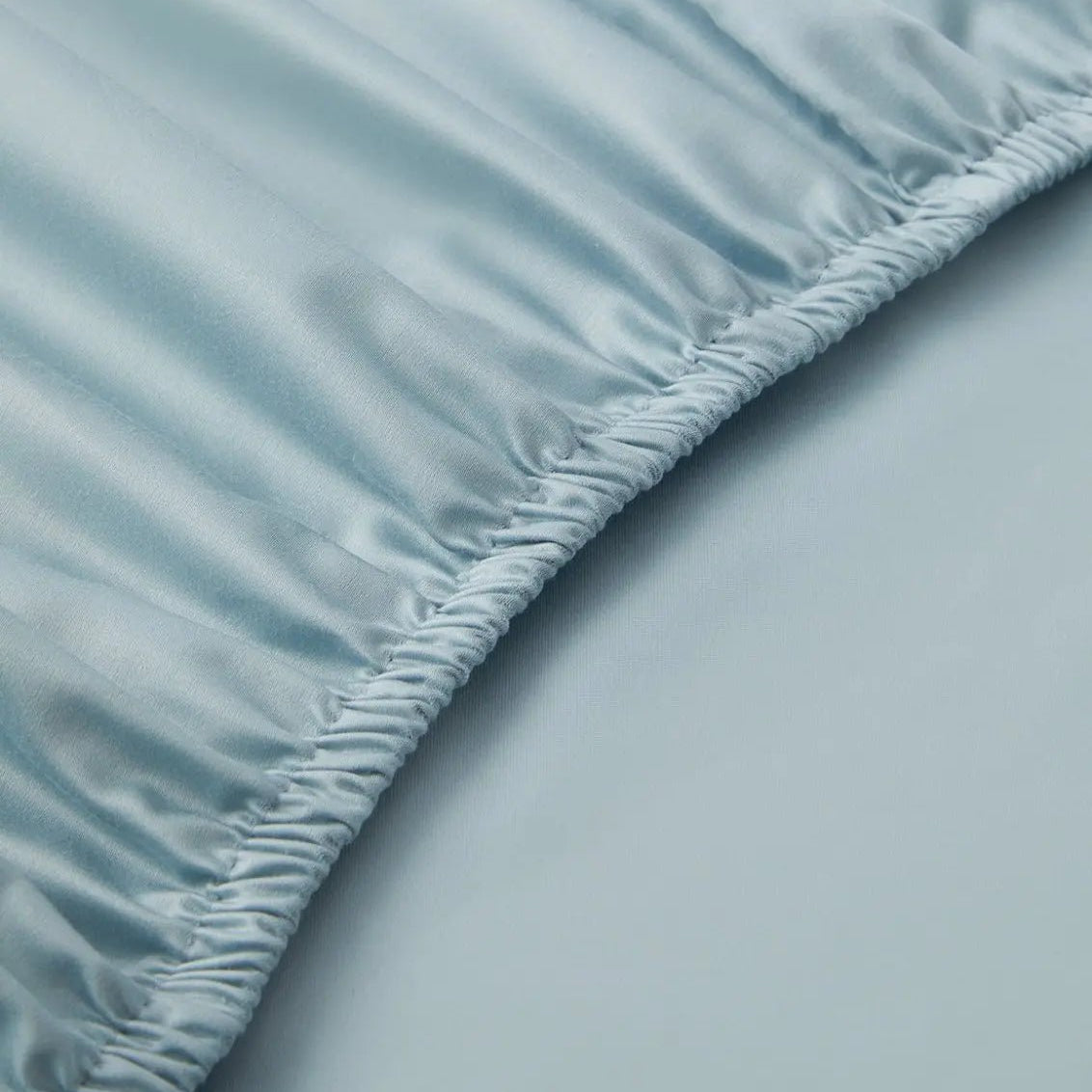 Close-up of a light blue fitted sheet on a bed