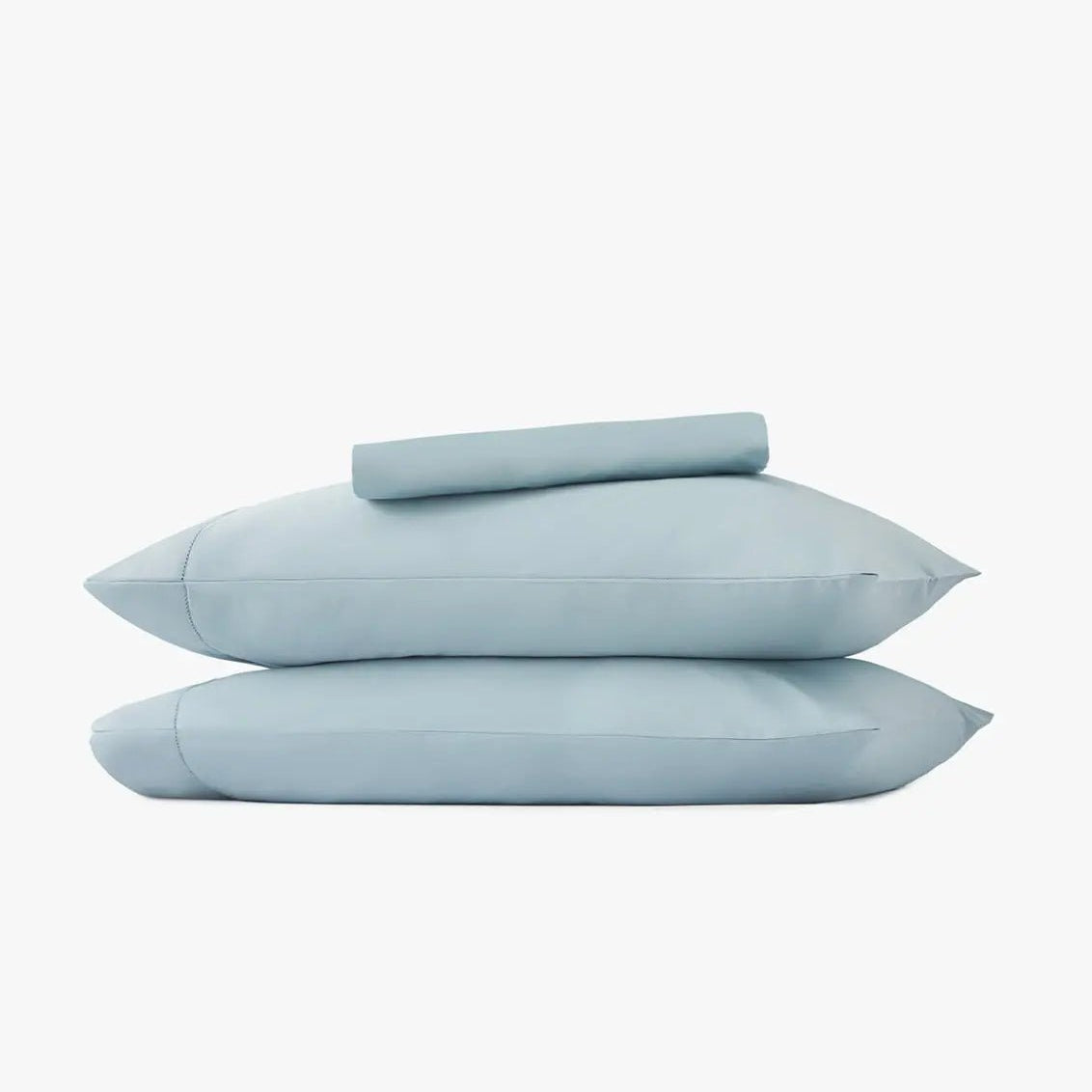 Set of light blue pillowcases and bed sheets on a white background
