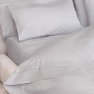 Gray bedding set on a bed with pillows