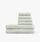 Stack of light pale mist green towels on a white background