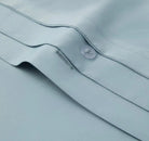 Close-up of a light blue bedding fabric with a button
