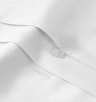 Close-up of a white bedding sheet with a button