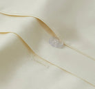 Close-up of a button on an ivory bedding fabric 