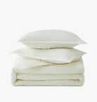 Stack of ivory pillows and duvet on a white background