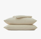 Beige bed sheets and pillowcases on a white background
