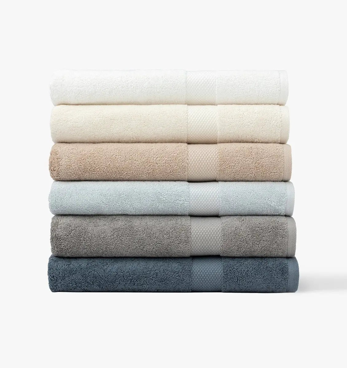 Stack of folded Premium Turkish Cotton towels in various colors on a white background