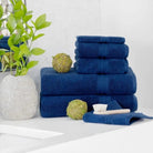 Stack of blue towels on a white bathroom surface with decorative items.