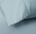 Close-up of a light blue bed sheet fabric with a subtle pattern 