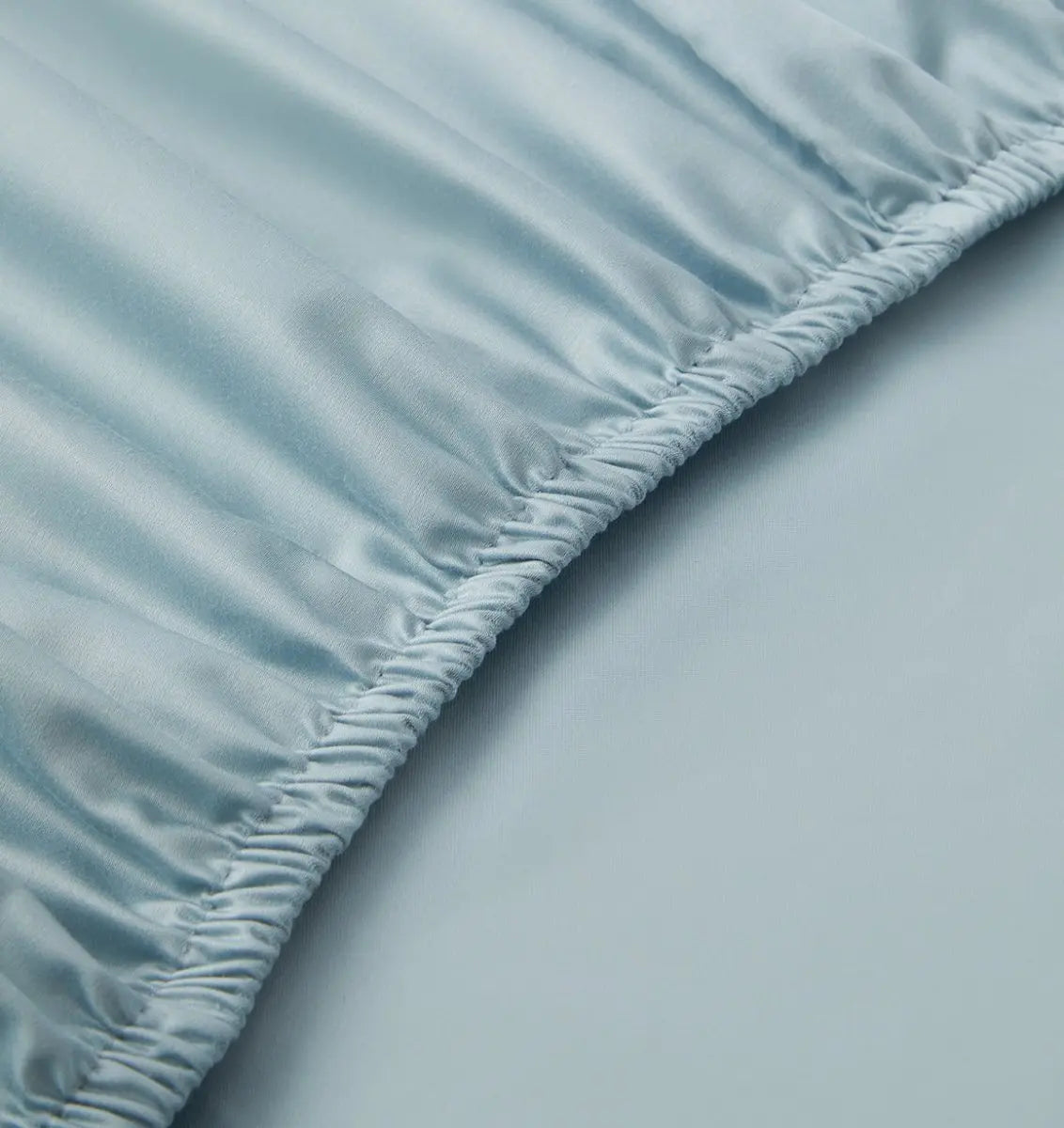 Close-up of a light blue fitted sheet on a bed
