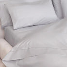 Gray sheet set bedding with pillows on a bed